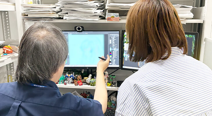 モニターに映した作画を指さしながらチェック内容を伝えている様子